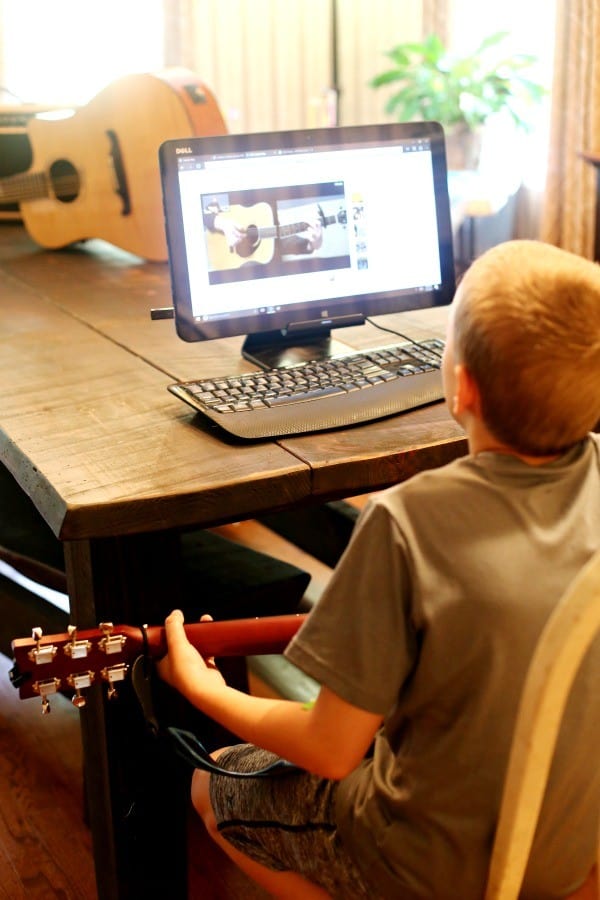 kid learning guitar at home