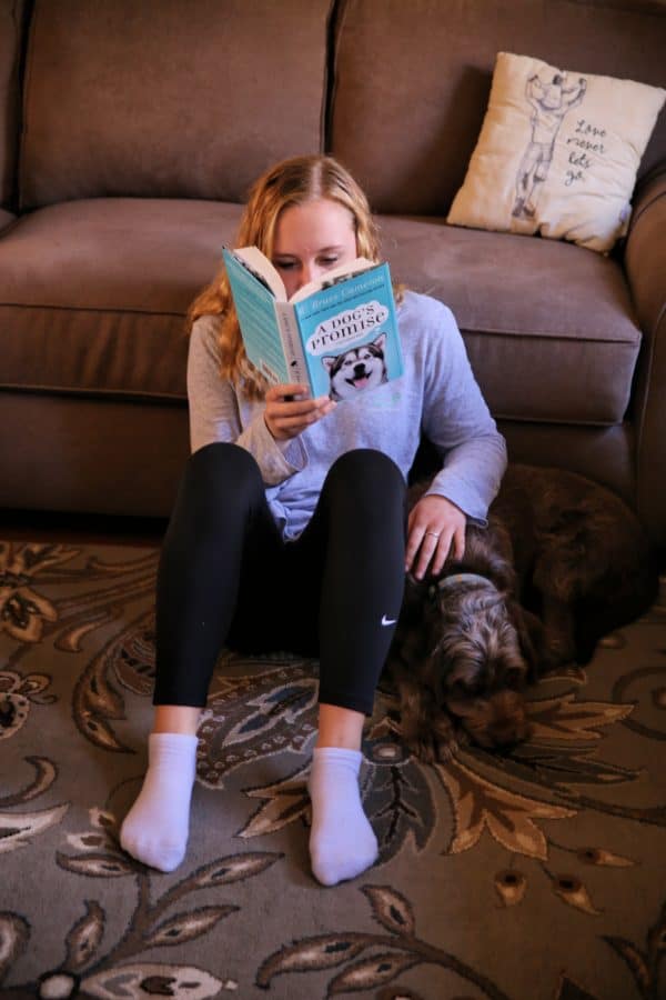 teen reading with dog