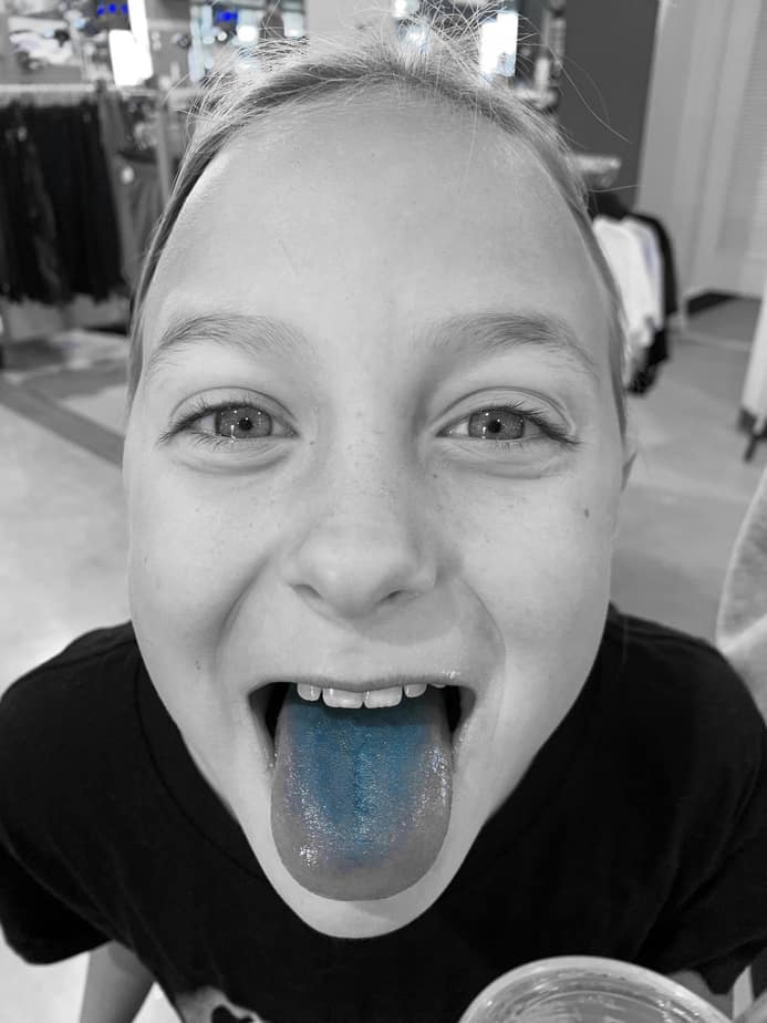 black and white photo of child with blue tongue 
