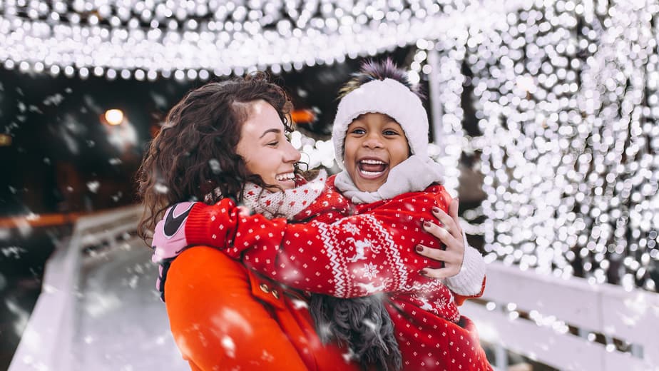 Little black girl enjoying in ice skating with her mother.