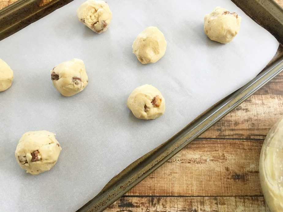 Snickers Cookies spooned onto parchment covered baking sheet before baking