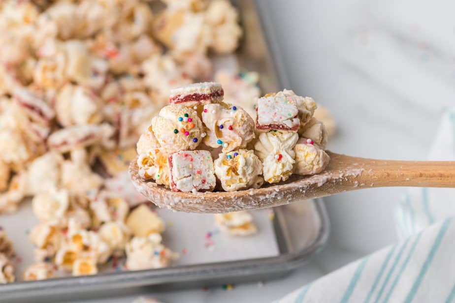 close up of strawberry glazed strawberry pop tart popcorn on wooden spoon