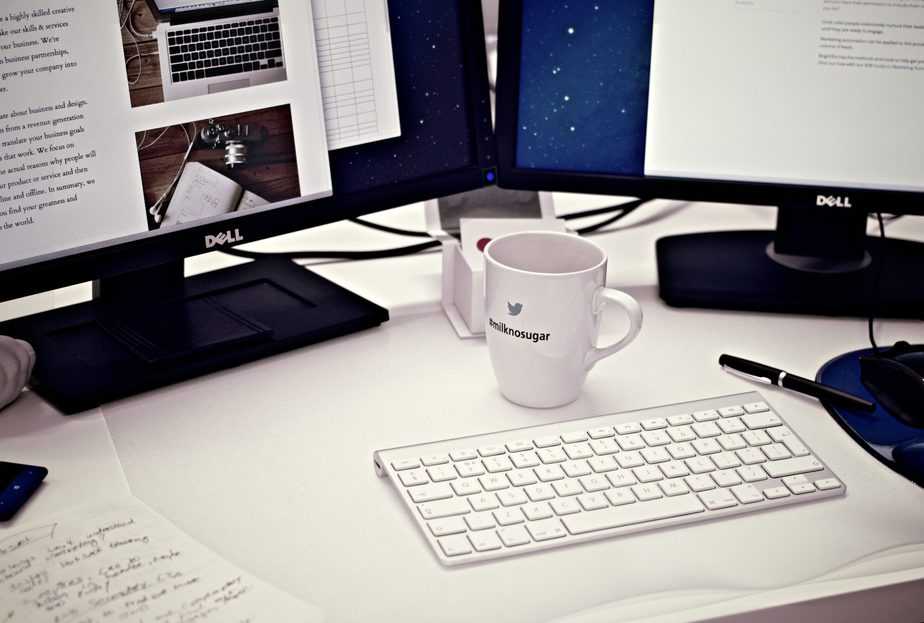 white coffee mug on desk with workstation and office supplies around 