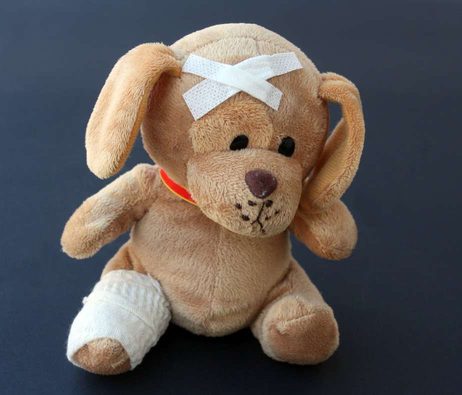 stuffed bear with bandages on head and leg