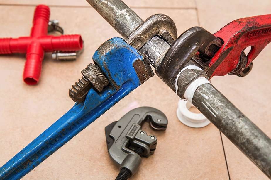 close up of wrenches on metal pipe