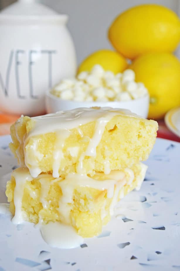 Lemon Blndies Brownies with lemon glaze stacked on white plate with confetti print 