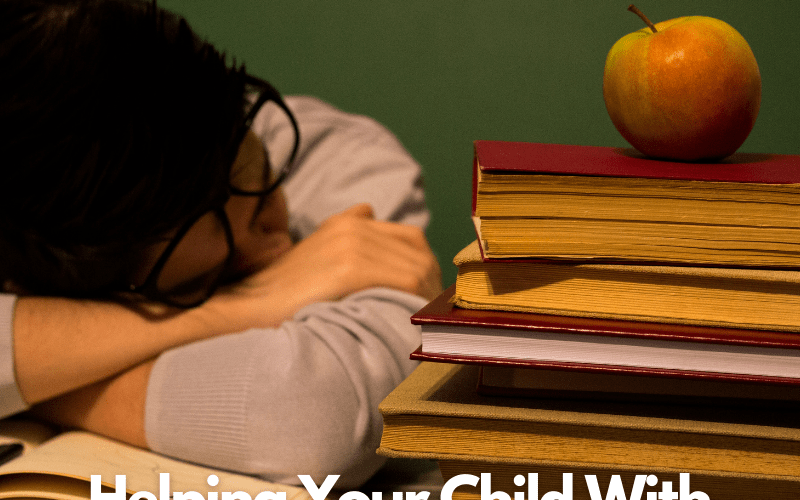 teen with head on top of homework papers with school books to the side