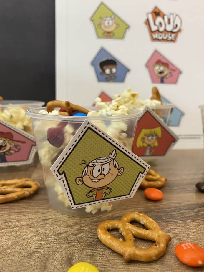 Snack mix in clear plastic cup with cutout image of Lincoln Loud from Nickelodeons the loud house taped to front