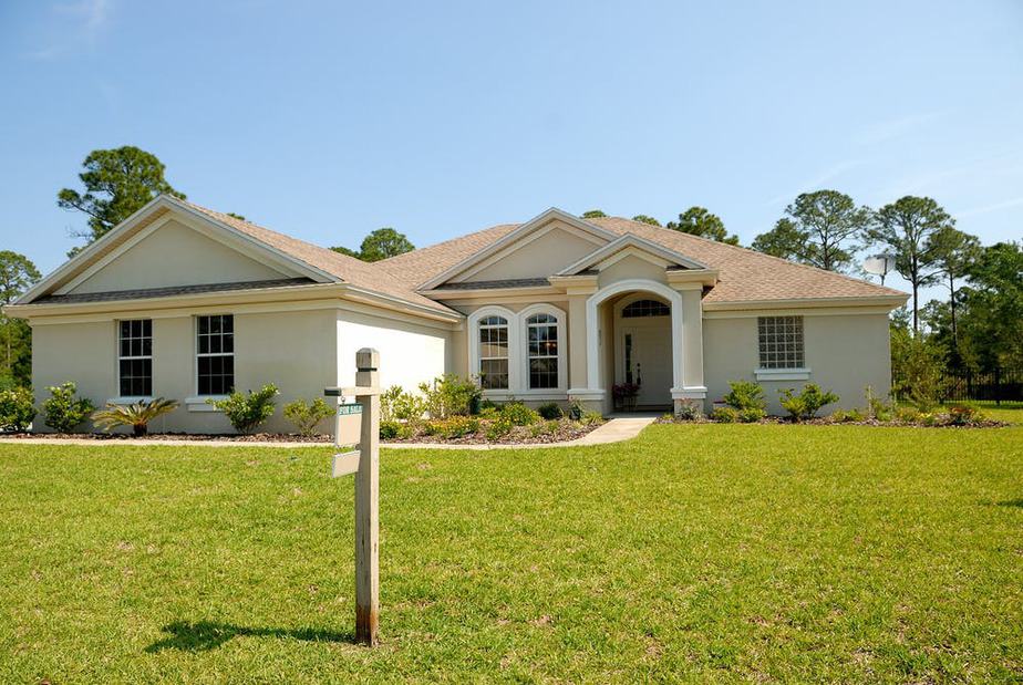 one story house with for sale sign in front yard 