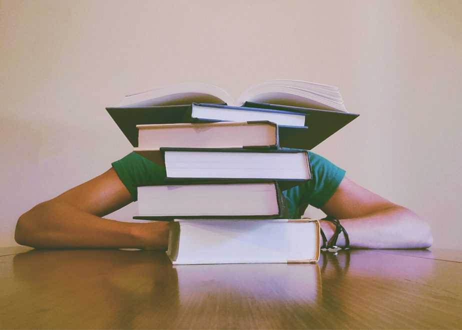 How To Help Your Teen Study teen behind pile of books on table