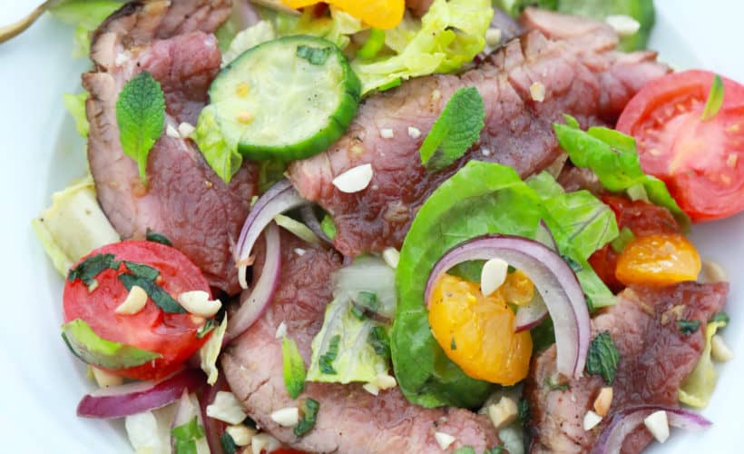 overhead shot of thai beef salad recipe served on white plate