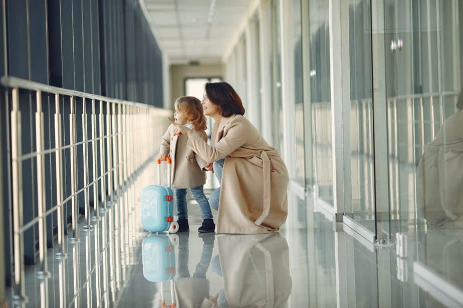 mother and toddler traveling through airport looking at something out of the image