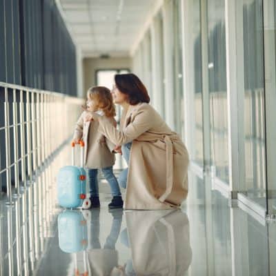 mother and toddler traveling through airport looking at something out of the image