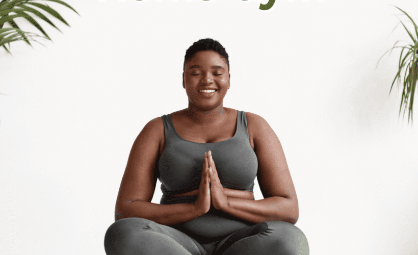 black woman with short hair with grey exercise clothes sitting in a yoga pose on grey yoga mat