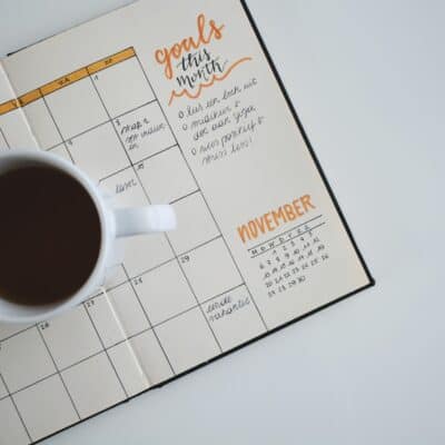 overhead view of open calendar page with cup of coffee sitting on top
